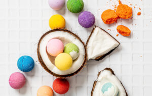 Custom product branding image for a Winnipeg company showing bright colourful bath bombs arranged in a broken coconut, professionally styled for marketing and brand content.