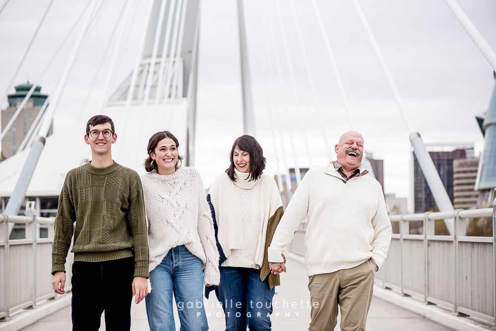 Family laughing and walking on a bridge in downtown Winnipeg