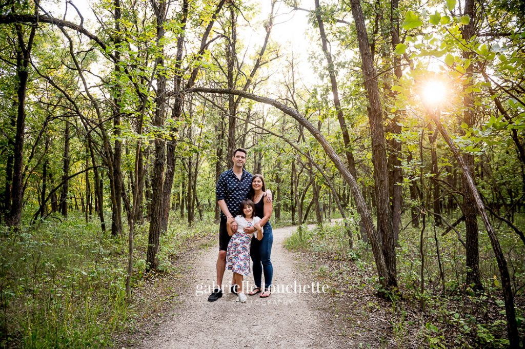 A family standing in a forest for a family photo session in Winnipeg