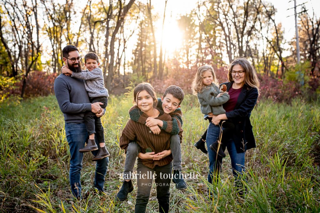 An October family photo session located in Saint Boniface at a park with lots of tall grass and woodsy areas