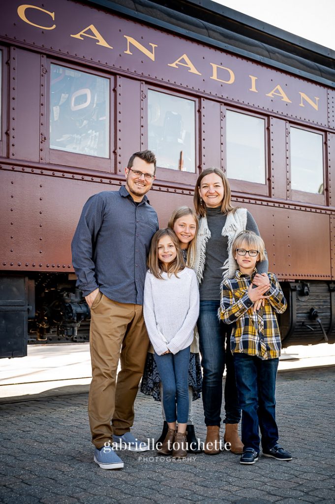 An old train as a background for a family photo at the Forks