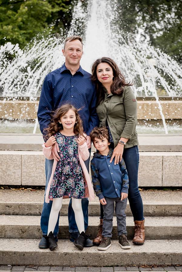 A family photo standing in front of a water fountain behind the Manitoba legislative building in Winnipeg