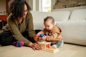 Professional commercial branding photo in Winnipeg featuring a mom and baby interacting with high quality toys in a home setting, captured for a local toy company’s marketing, advertising, and ecommerce website.