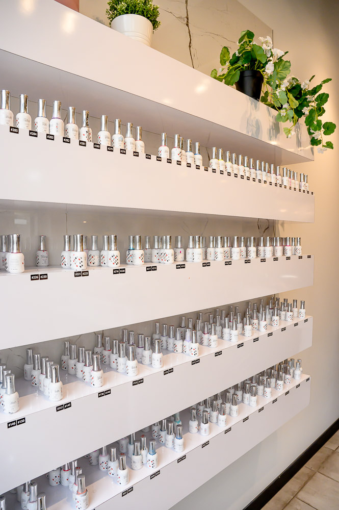 Rows of premium nail polish bottles available for customers to choose at Almond Nail Bar