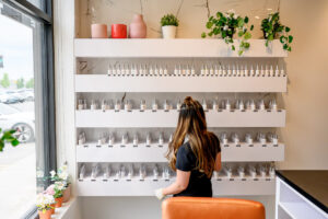 Action photography of a nail bar store with a row of nail polish to choose from, photographed for a branding session for a Winnipeg business.