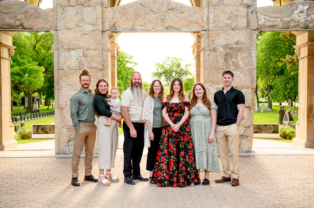 family posing with high school graduate for photo session at St. Boniface Cathedral