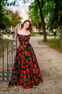 grad photo session in Winnipeg, posing next to an iron gate