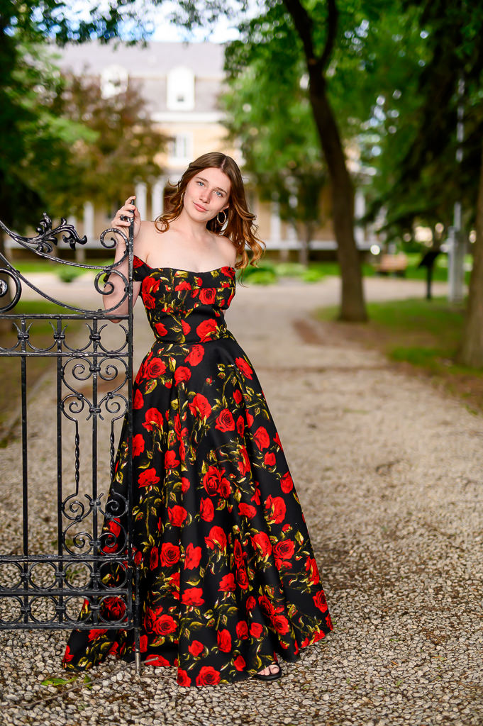 grad photo session in Winnipeg, posing next to an iron gate