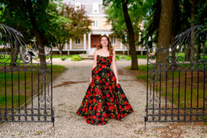 High School Grad Portraits at a historical location in Winnipeg with black iron gate and driveway