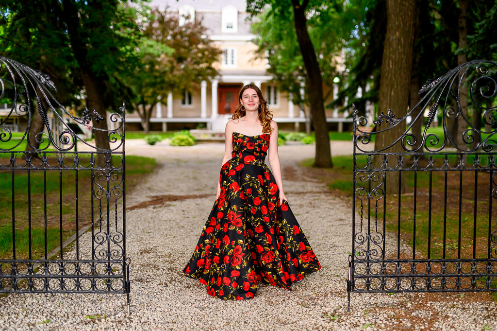 High School Grad Portraits at a historical location in Winnipeg with black iron gate and driveway