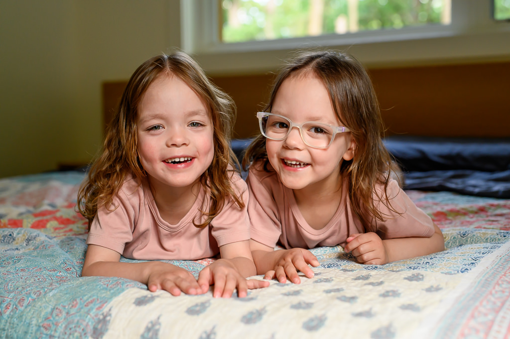 Photo of an identical twin sisters laughing and smiling together