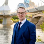 Professional headshots in Winnipeg in a natural outdoor setting against the city skyline.