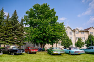 Classic car enthusiasts talking together at a community event