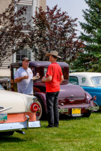 Classic car owner sharing stories about his vintage automobile